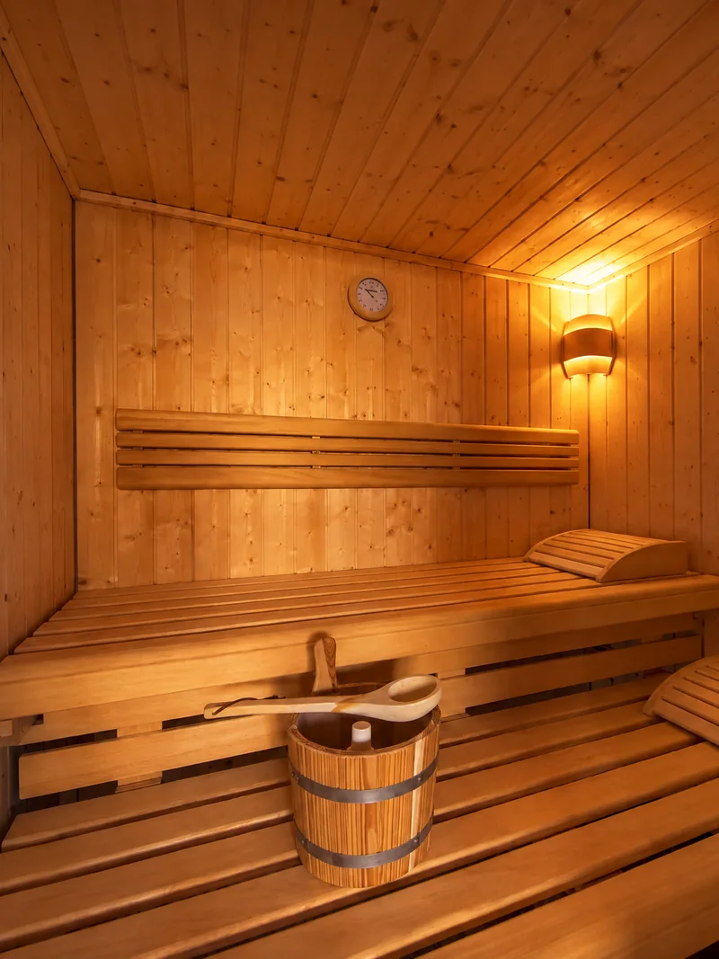 Die finnische Sauna im warmen Licht, mit Holzbänken und Kübel