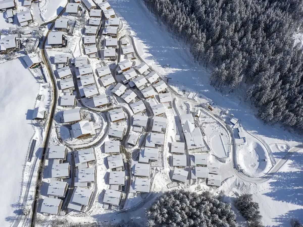 Das Chaletdorf im Winter von oben, dahinter das Tal und die Gipfelkette