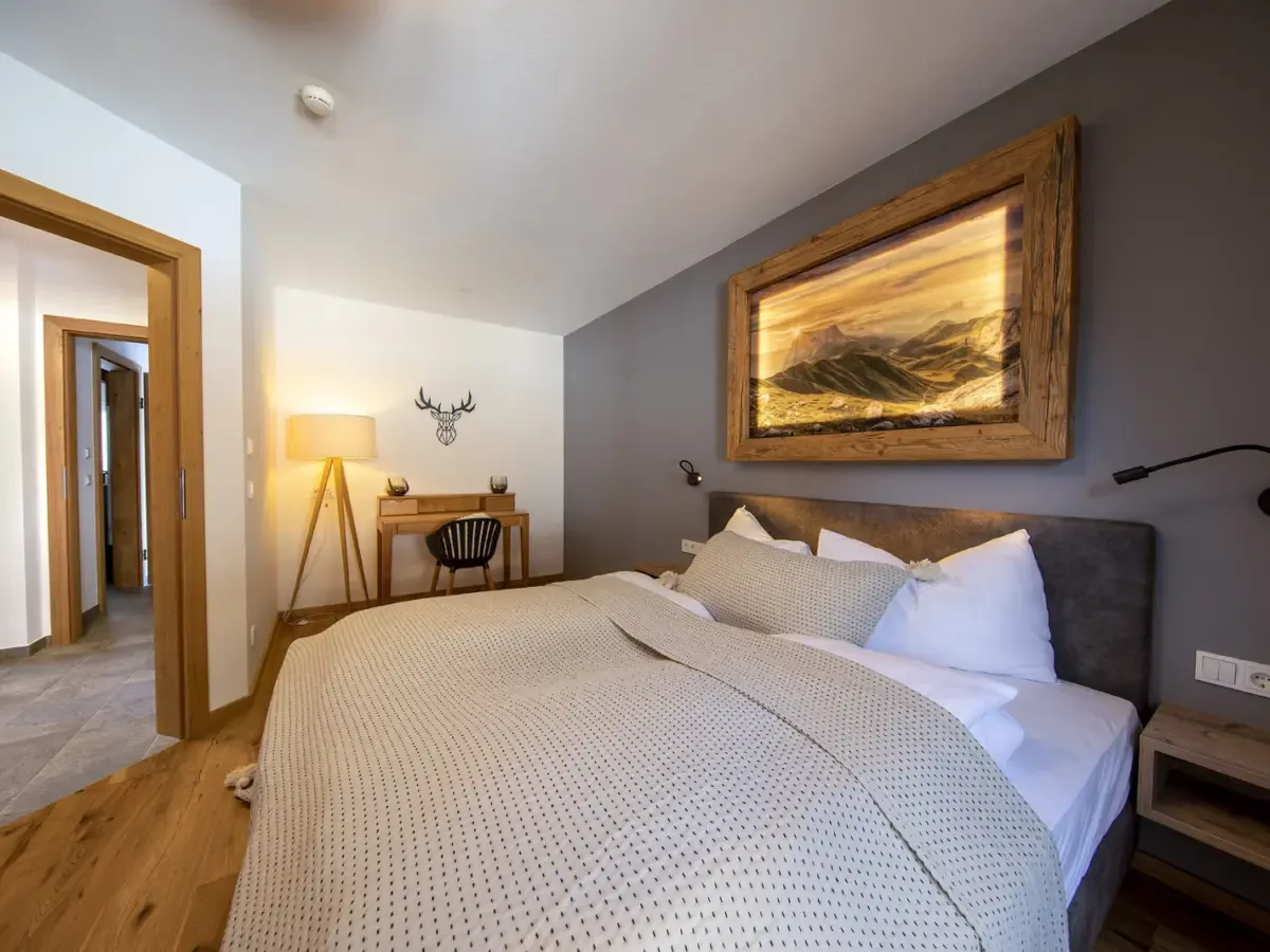 Schlafzimmer mit Doppelbett, Schreibtisch und Stehlampe