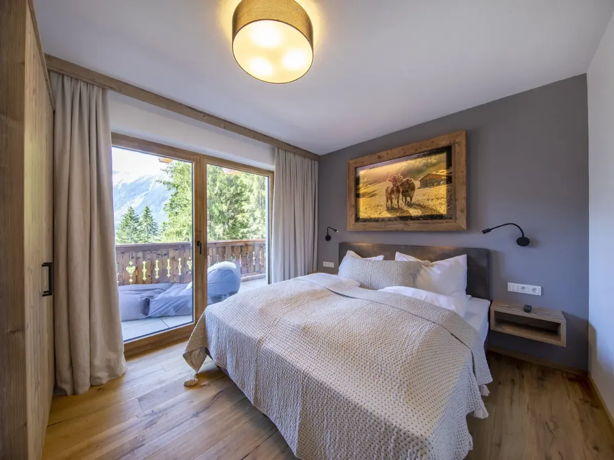 Schlafzimmer mit Doppelbett und Tür zur Terrasse