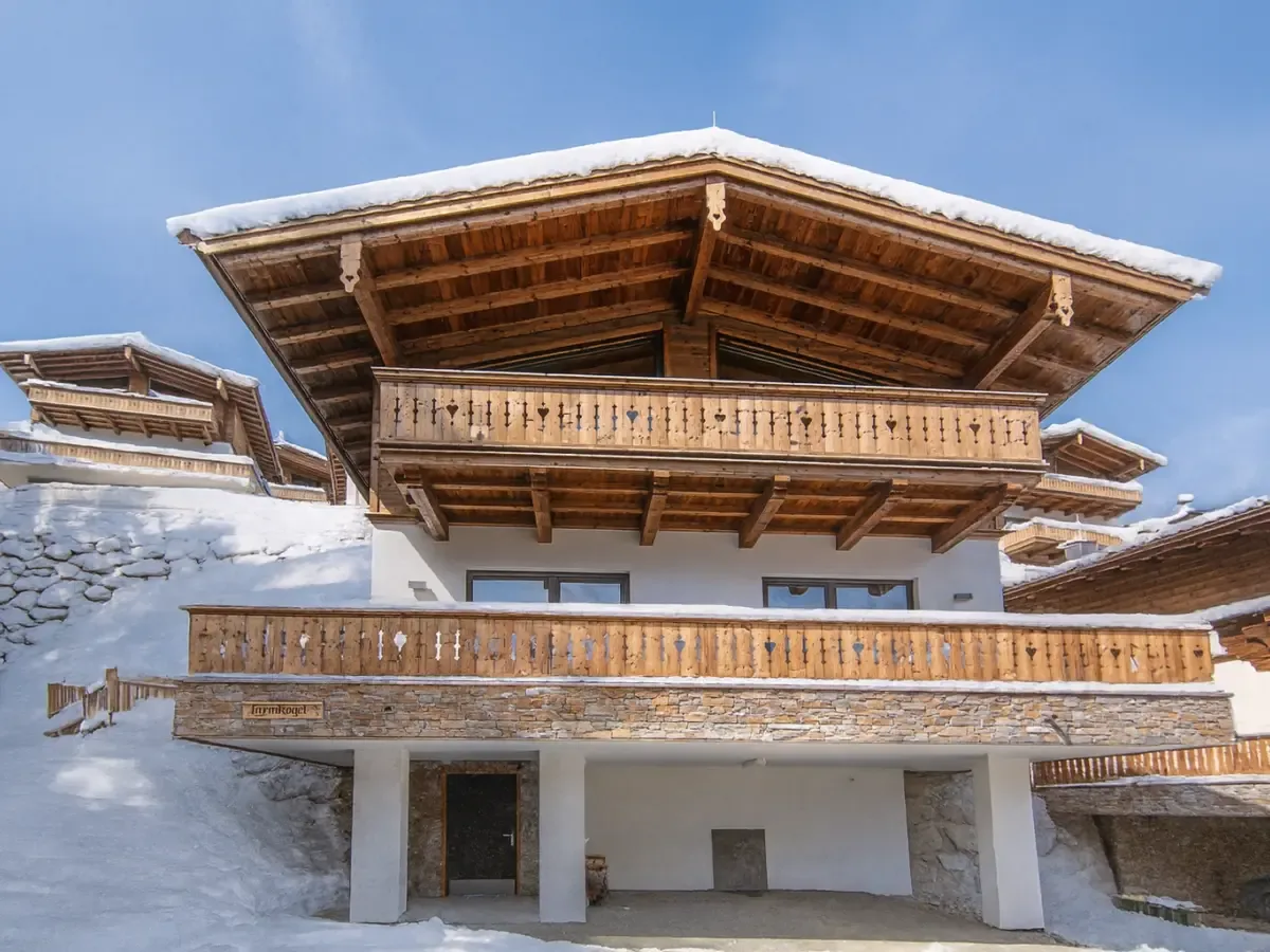 Das Chalet Larmkogel von vorn, tief verschneit, mit Balkon und weitem Dachvorsprung