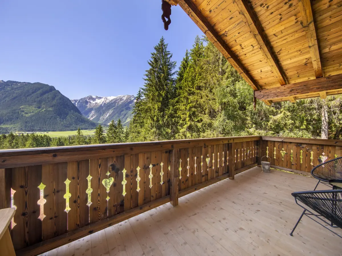 Die Terrasse des Chalets im Sommer mit Blick über das Tal auf die Berge