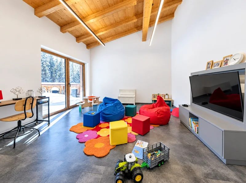 Das Spielzimmer mit bunten Sitzsäcken, Spielteppich und Spielzeug