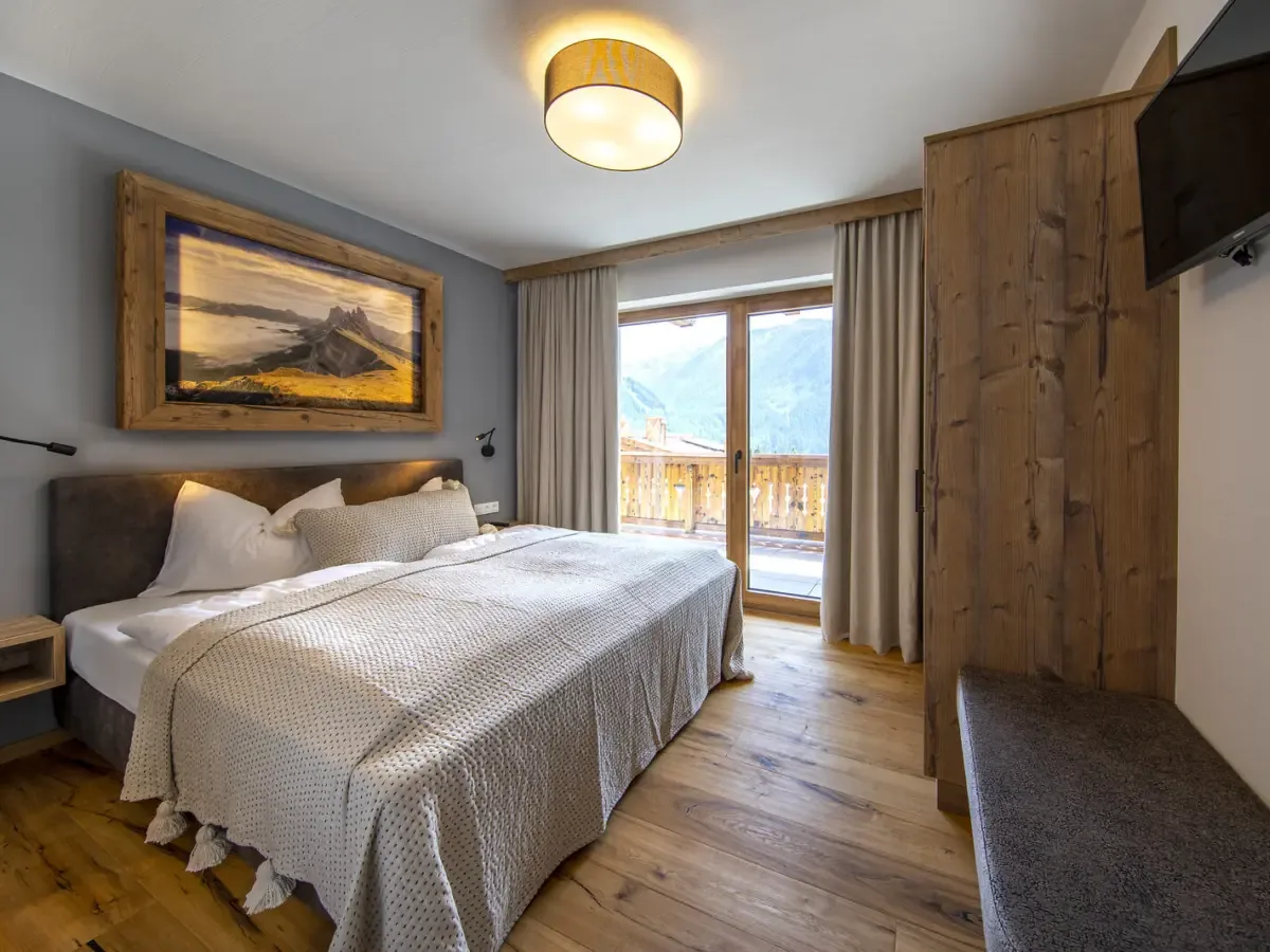 Schlafzimmer mit Balkontür und Blick auf die Berge